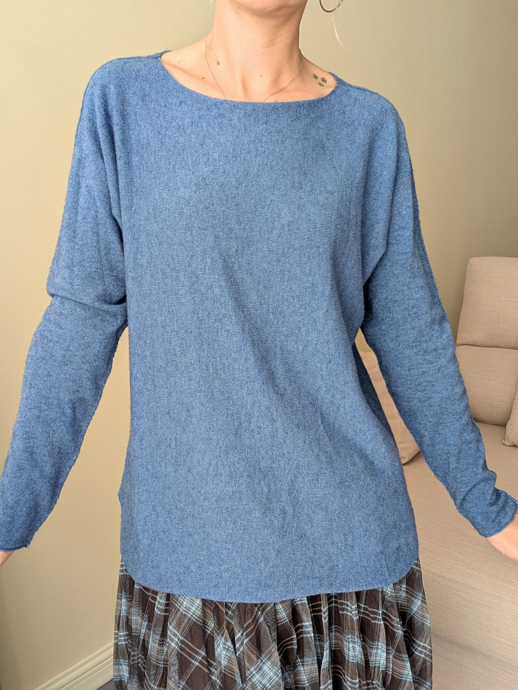 Jersey azul de manga larga llevado por fuera de la falda