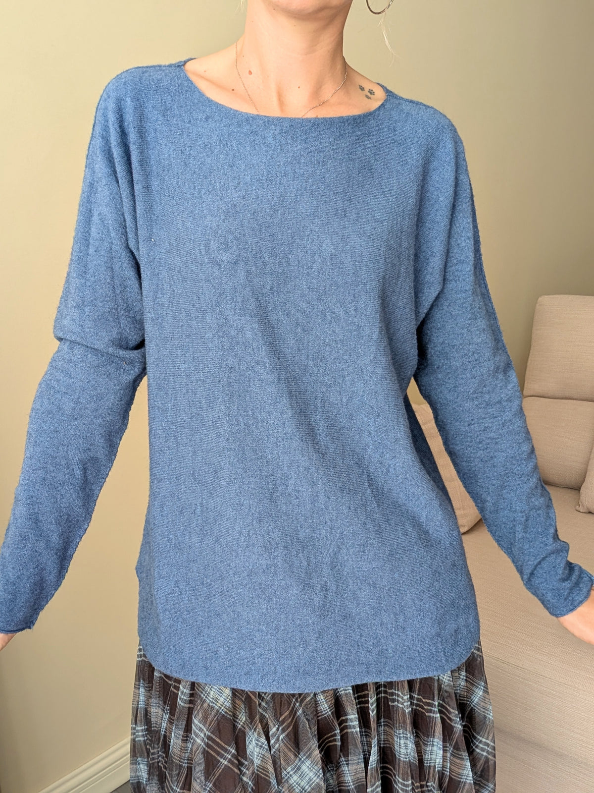 Jersey azul de manga larga llevado por fuera de la falda