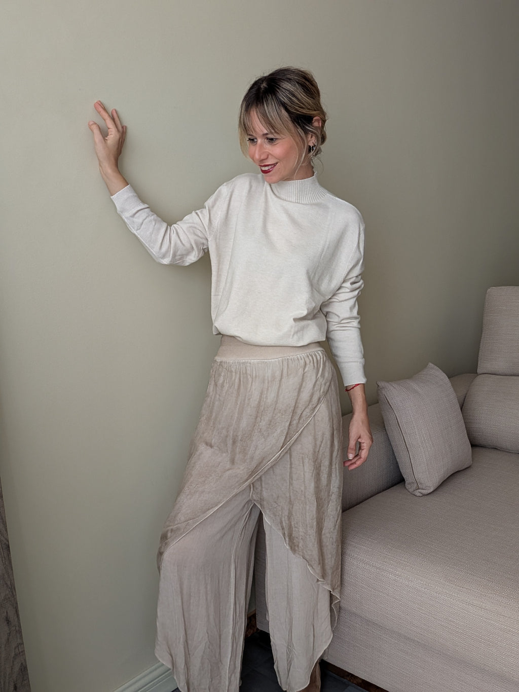 Jersey crudo de cuello alto combinado con pantalón fluido y botines