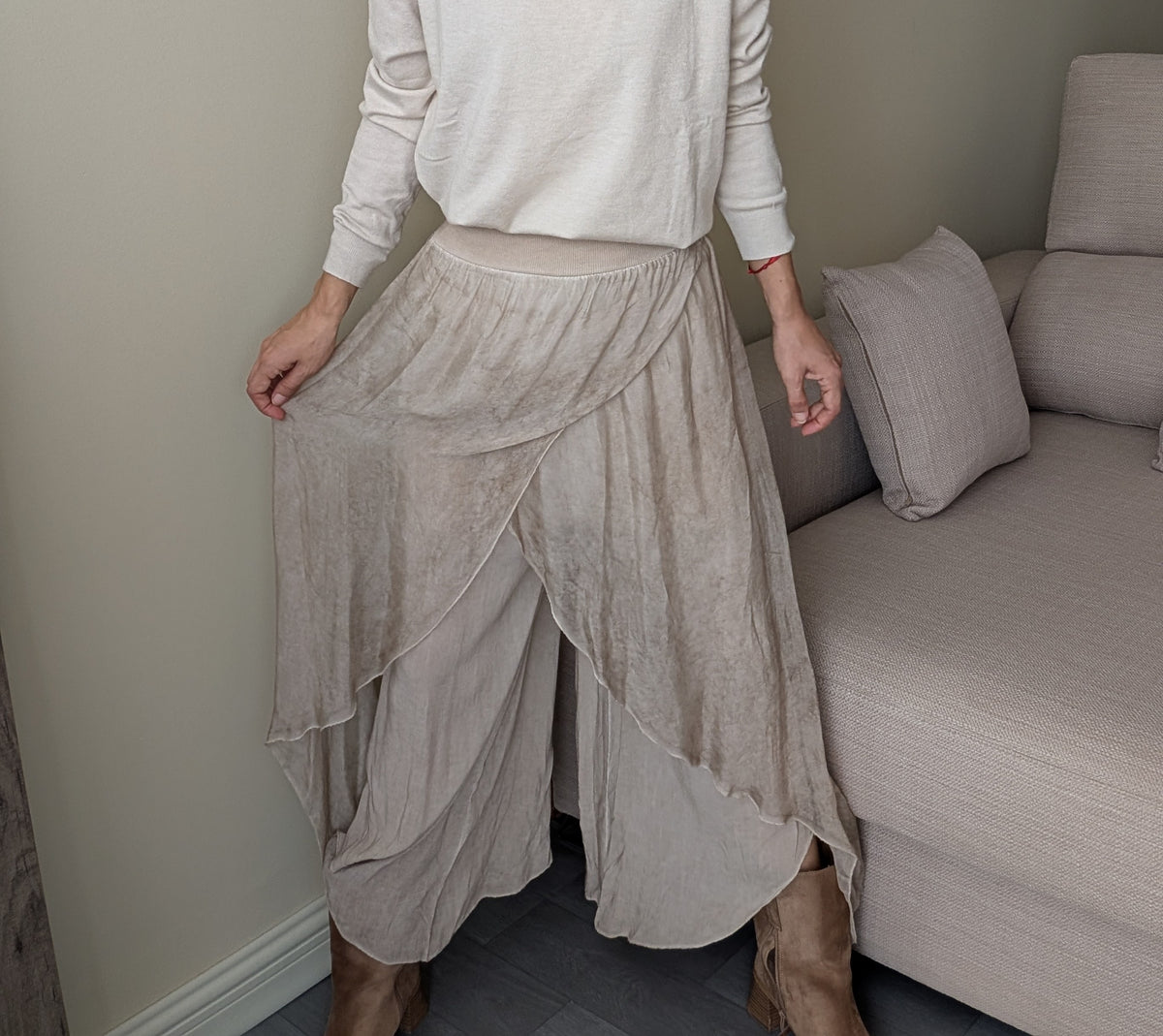 Pantalón beige de capas asimétricas, detalle frontal de cintura y tejidos superpuestos