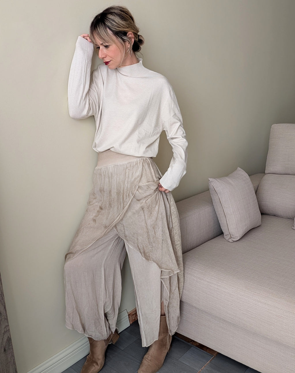 Vista frontal del pantalón beige ancho con capas y bajos desiguales