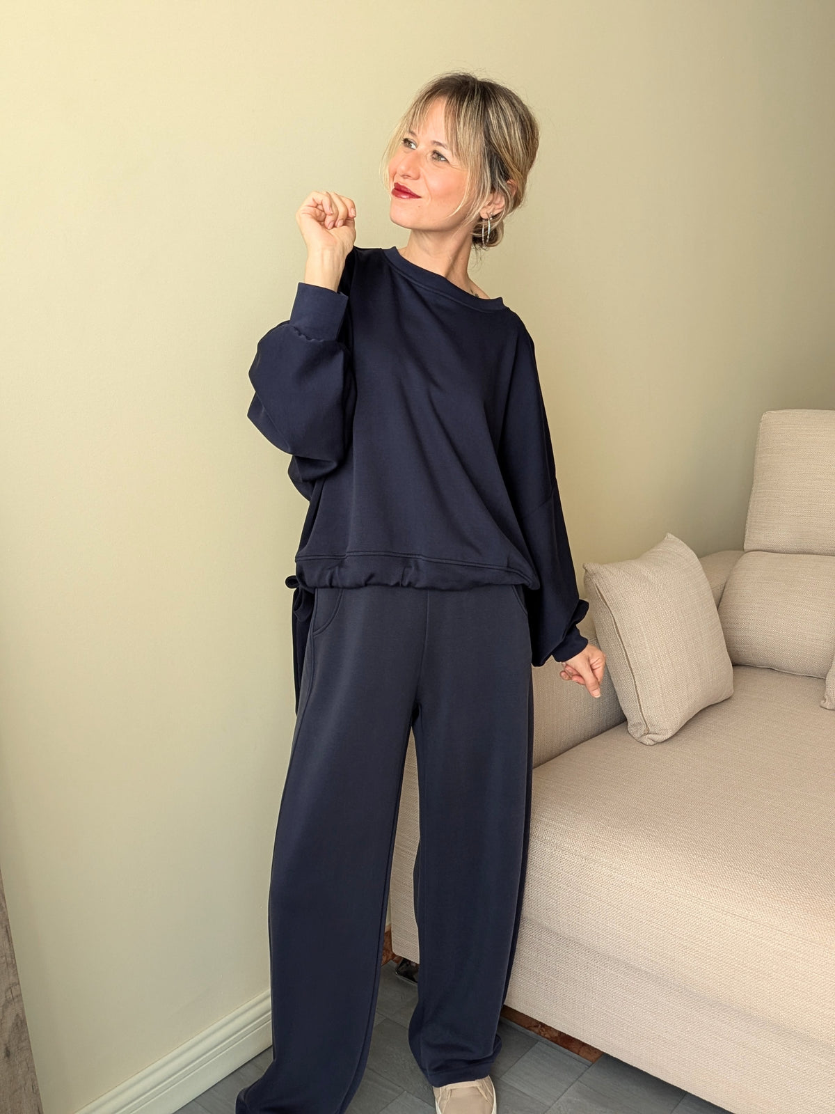 Conjunto azul marino de manga larga y pantalón ancho llevado con zapatillas