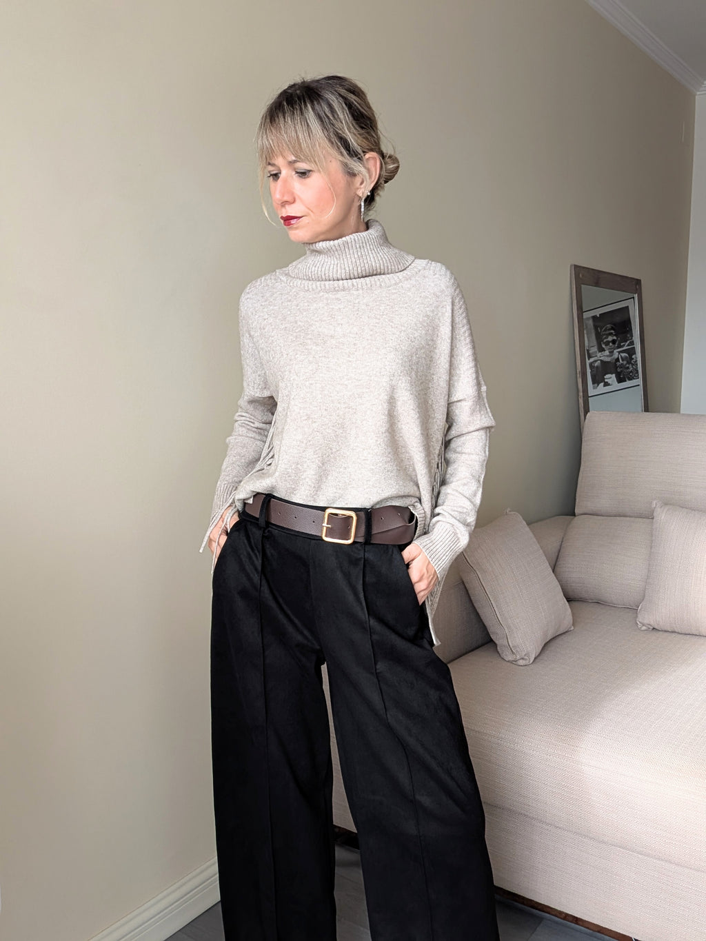 Pantalón negro con bolsillos combinado con jersey de cuello alto.