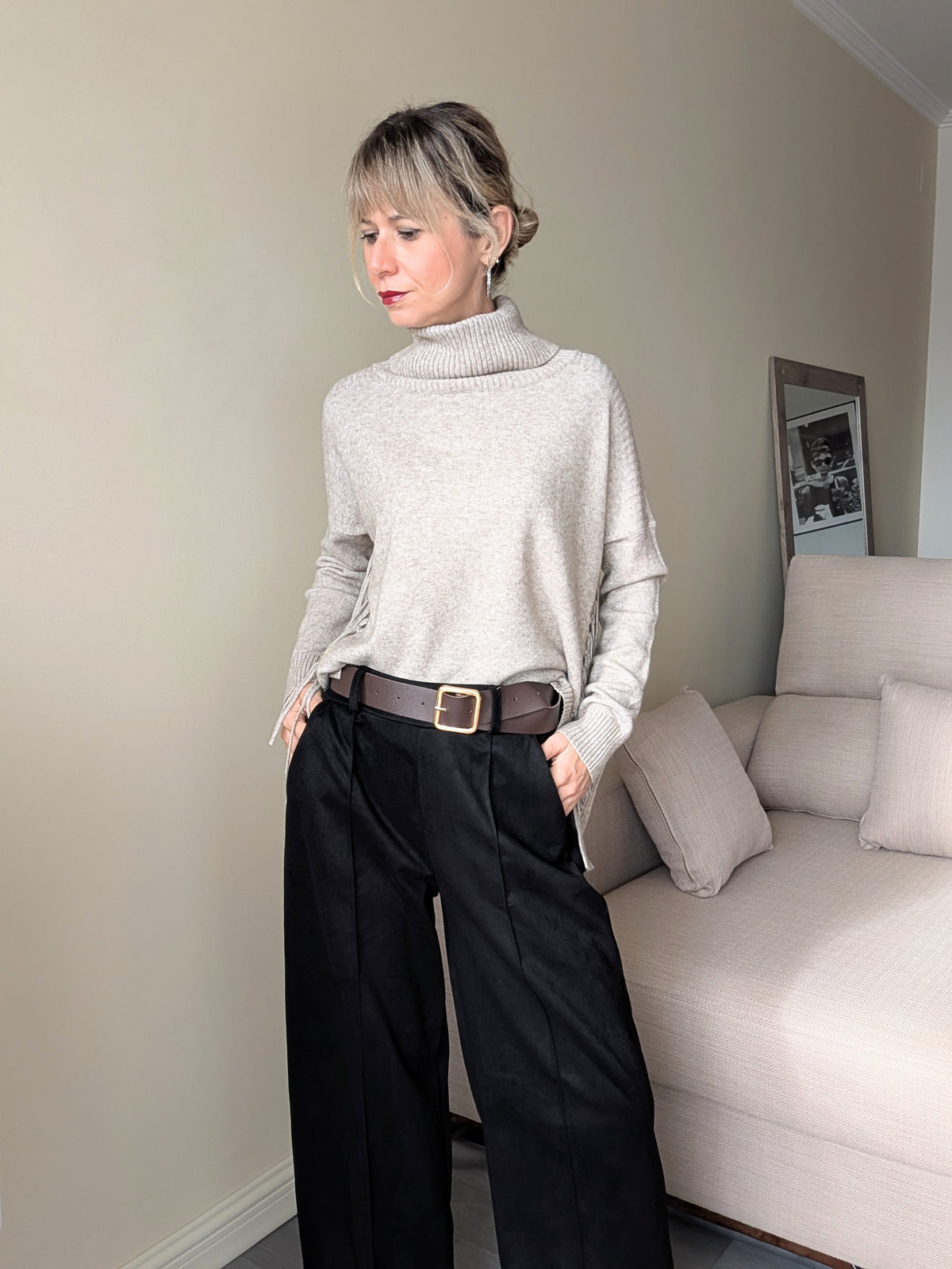 Pantalón negro con bolsillos combinado con jersey de cuello alto.
