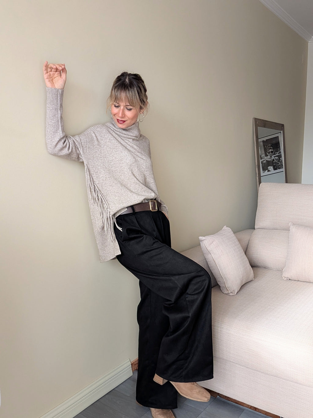 Pantalón negro de pierna ancha en movimiento, combinado con jersey gris jaspeado.