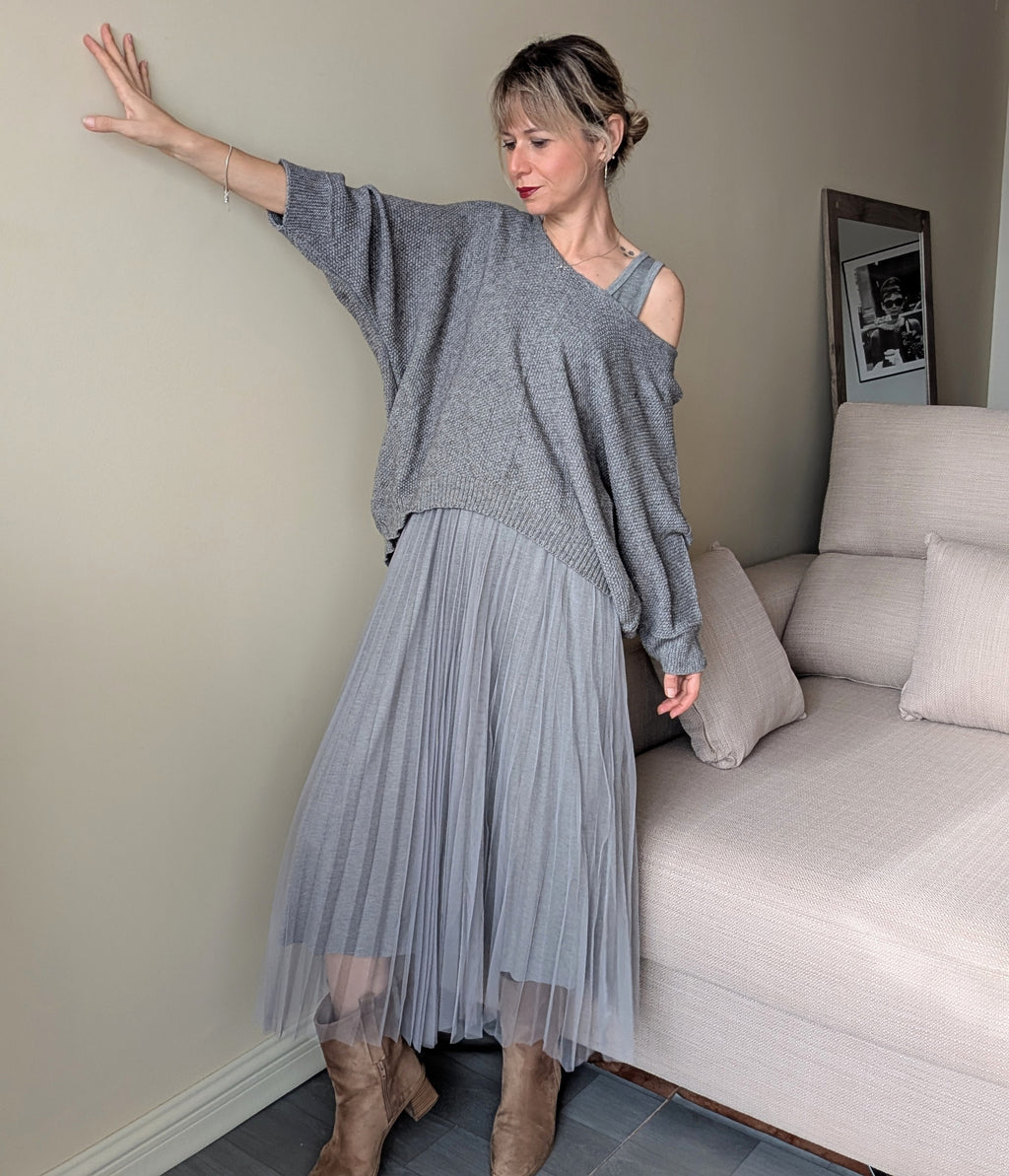 Conjunto gris de vestido plisado y jersey amplio de punto, vista frontal completa.