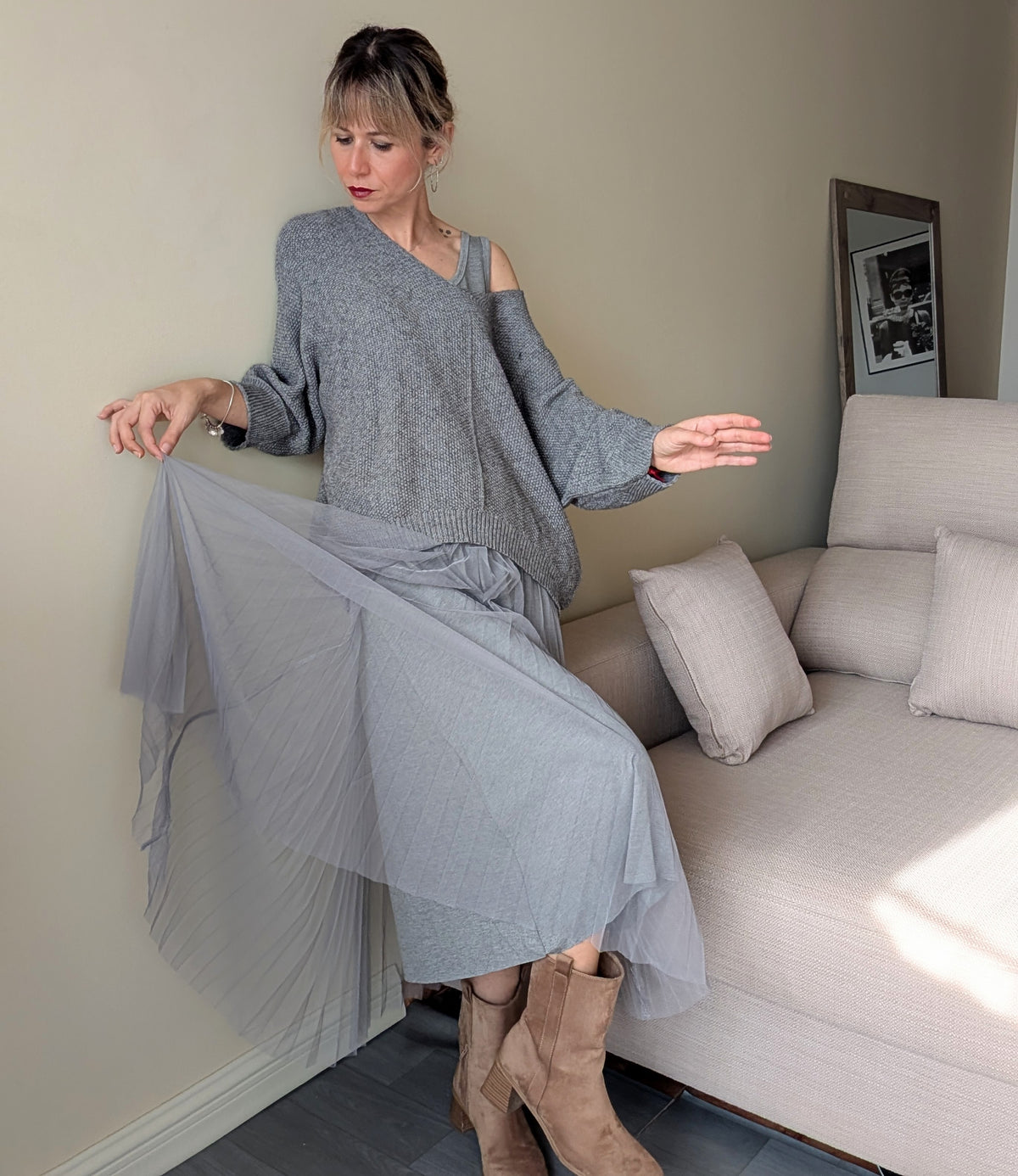 Detalle del movimiento de la falda plisada del vestido gris con jersey.