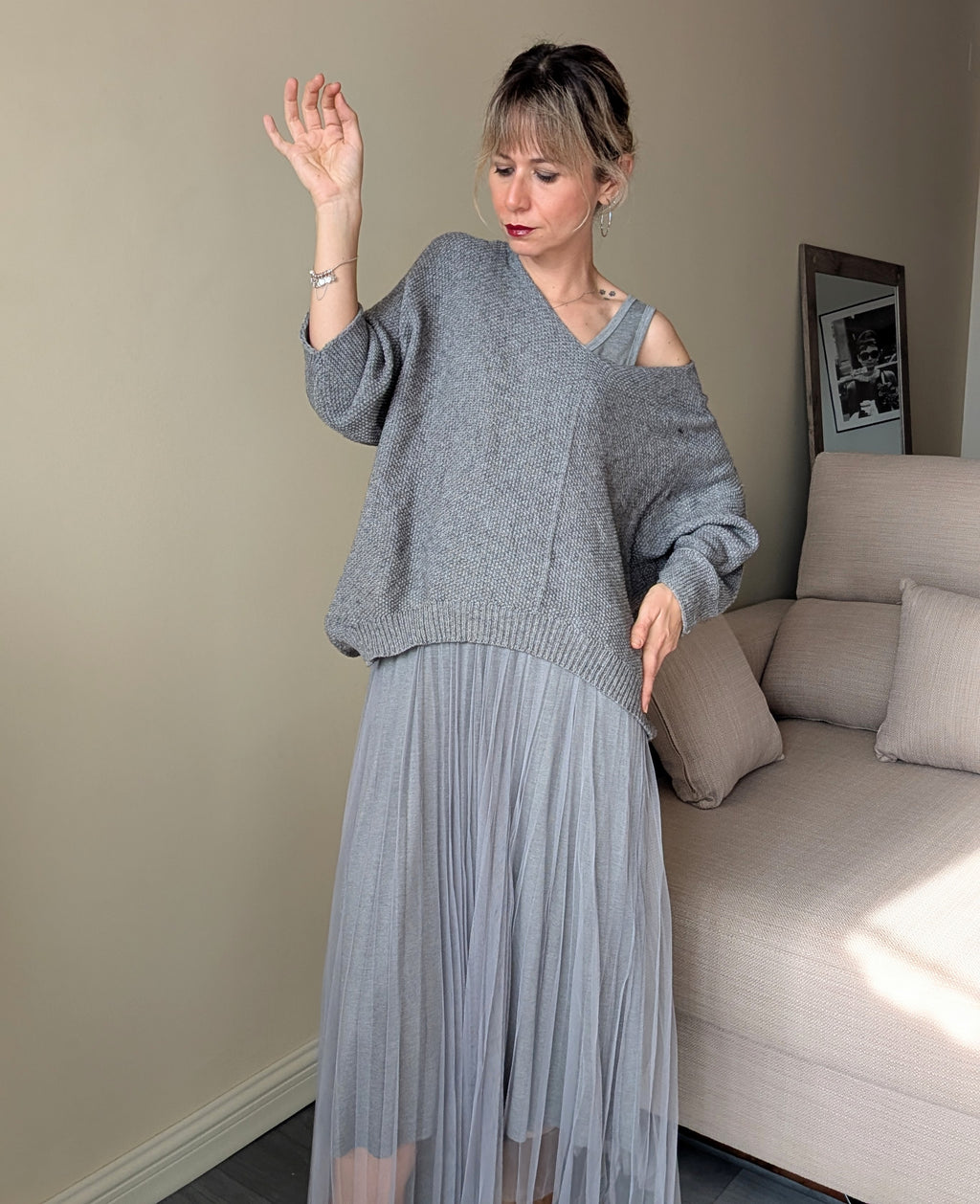 Vista frontal del conjunto gris de dos piezas con vestido plisado y jersey amplio.