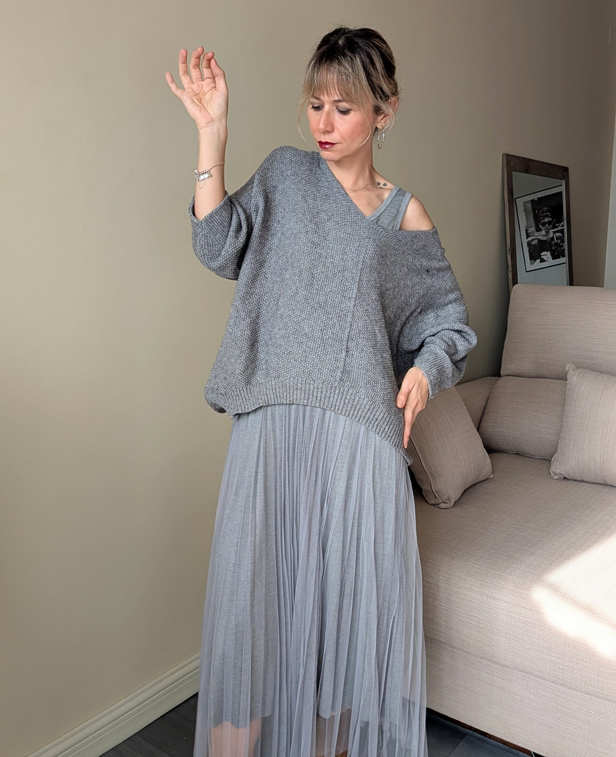 Vista frontal del conjunto gris de dos piezas con vestido plisado y jersey amplio.