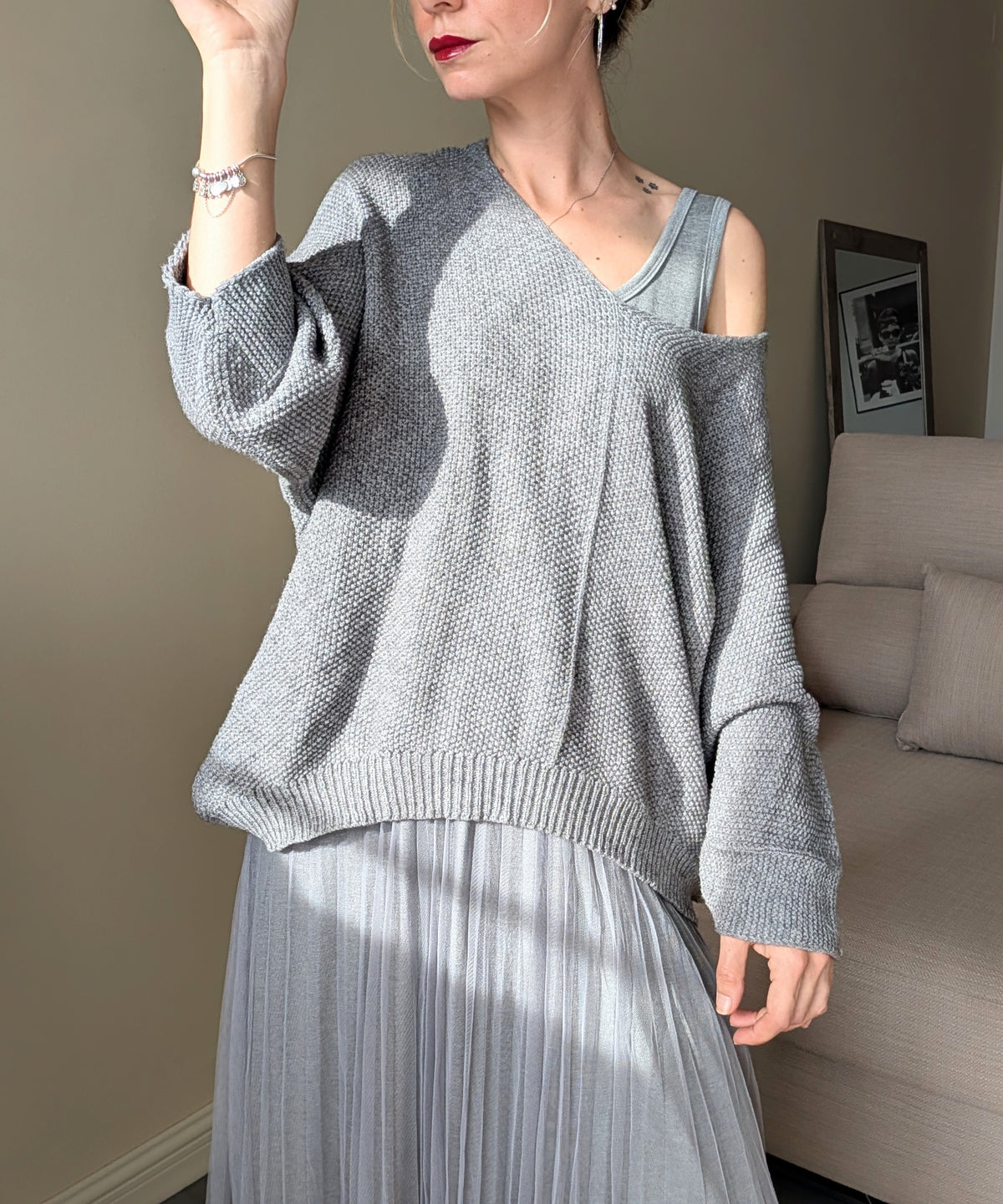 Detalle del punto del jersey gris y del cuerpo sin mangas del vestido.