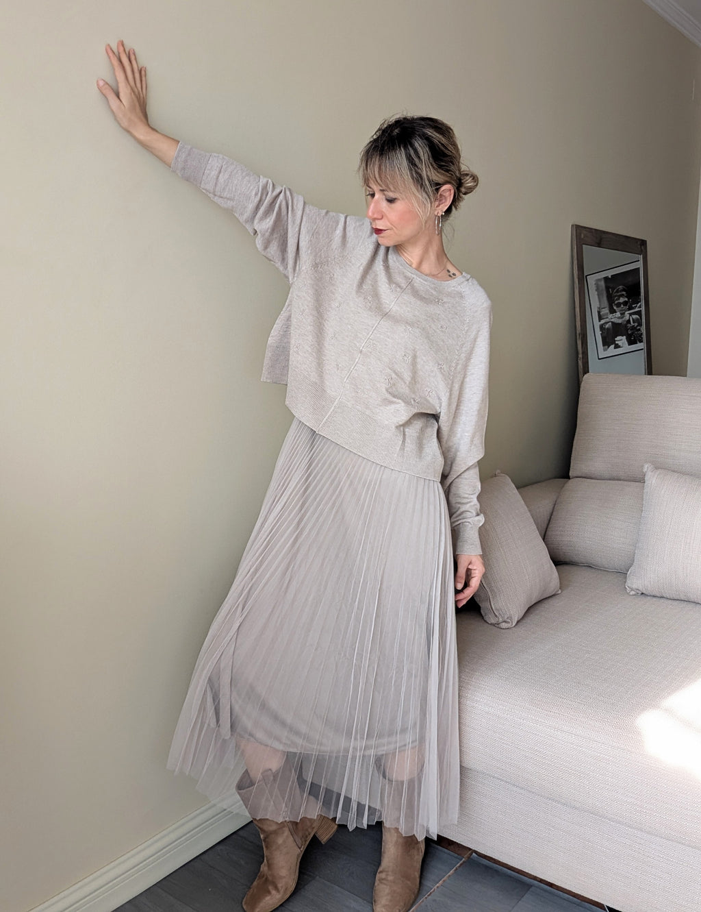 Vista completa del conjunto beige con jersey corto y falda plisada del vestido.