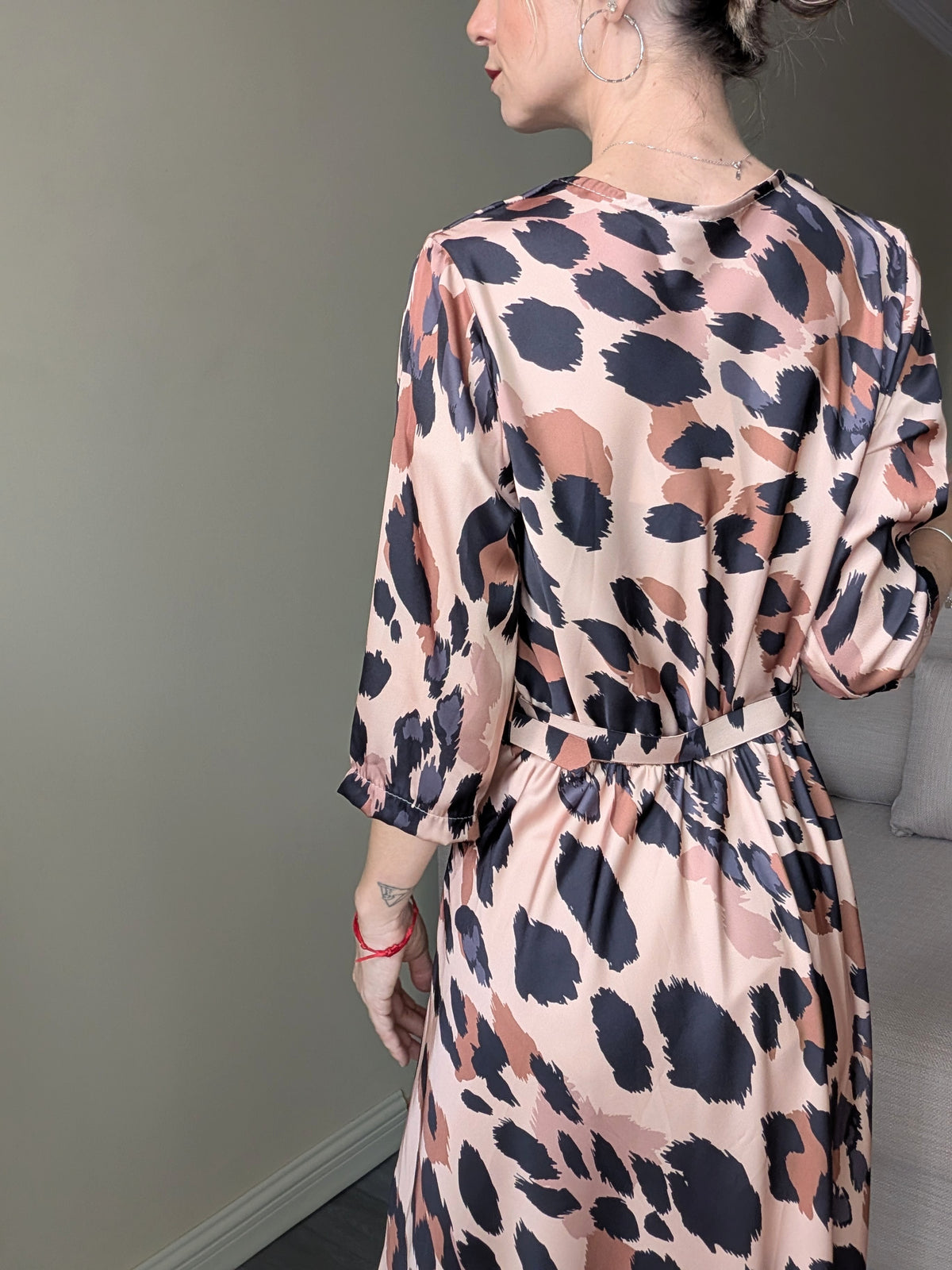 Vista trasera del vestido satinado animal print con cinturón a juego.