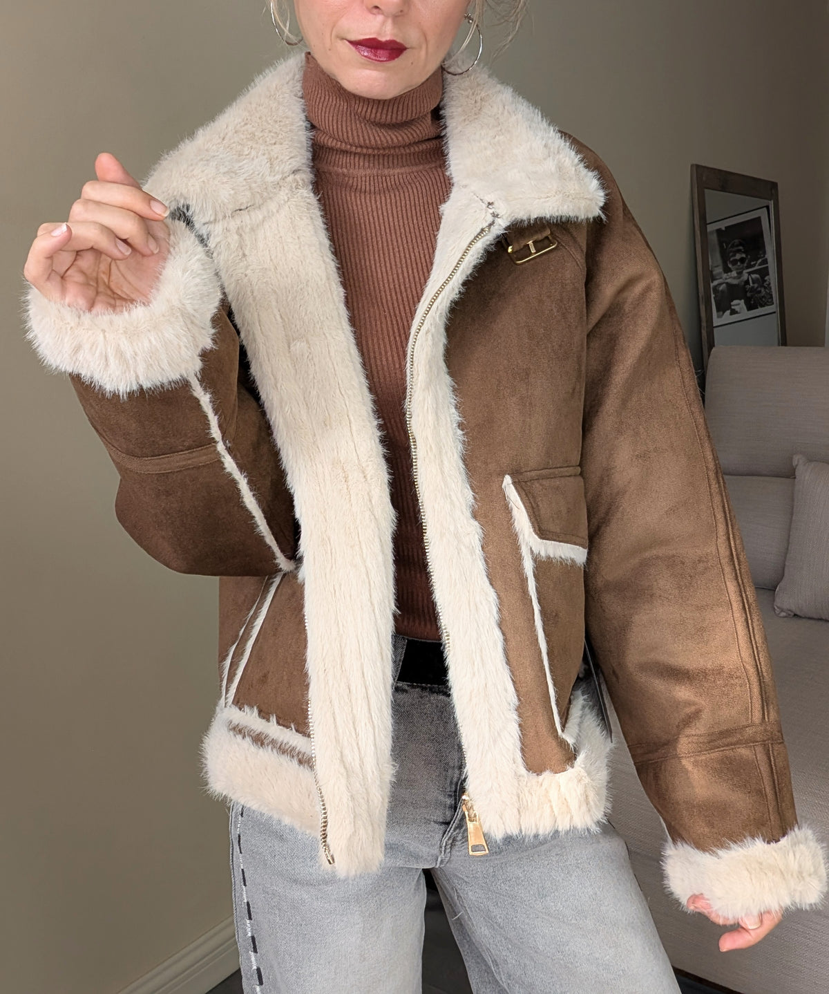 Vista frontal de chaqueta marrón abierta con cremallera y cuello de pelo crudo.