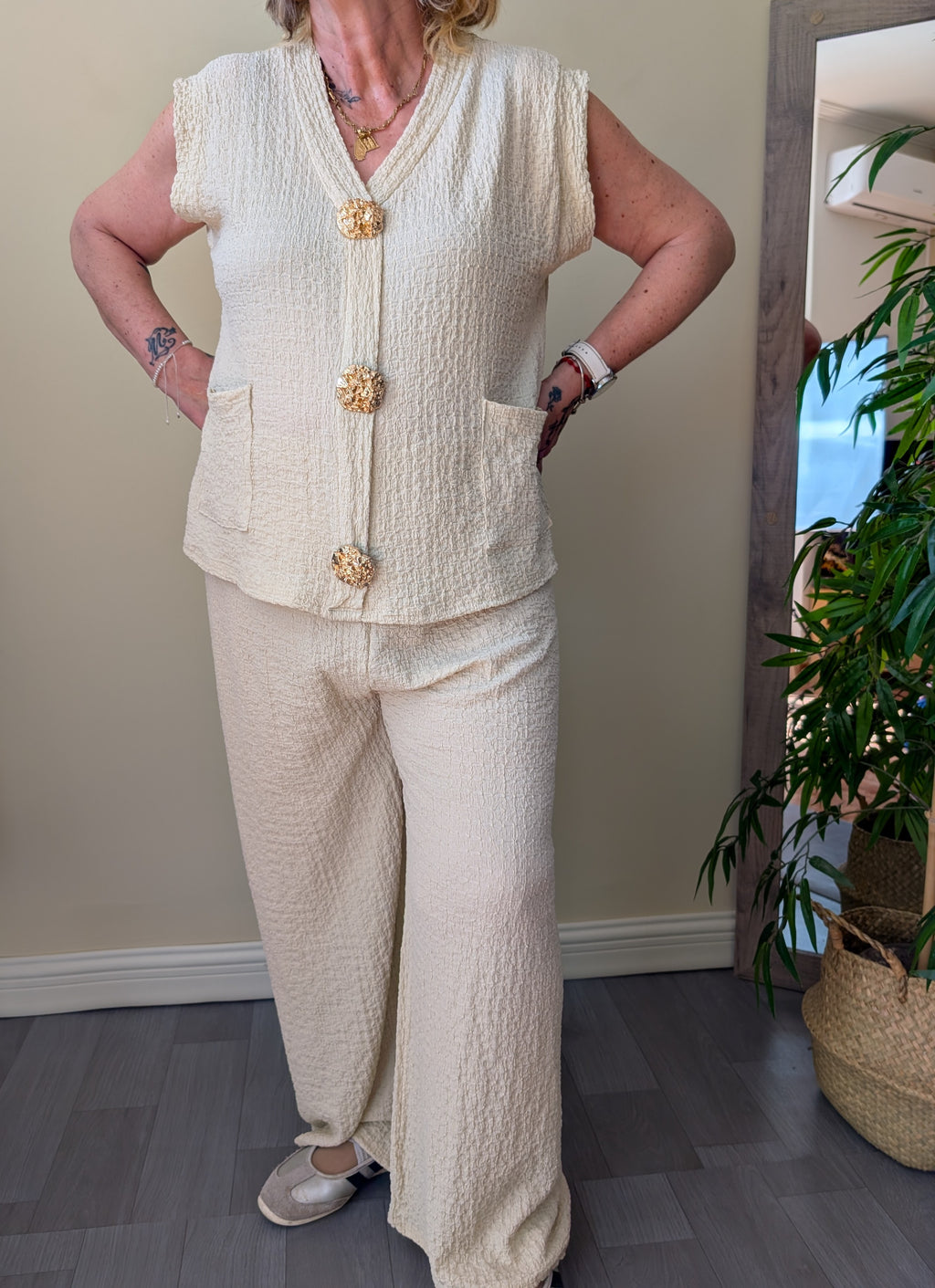 Conjunto beige de chaleco con botones dorados y pantalón de pierna ancha