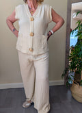 Conjunto beige de chaleco con botones dorados y pantalón de pierna ancha
