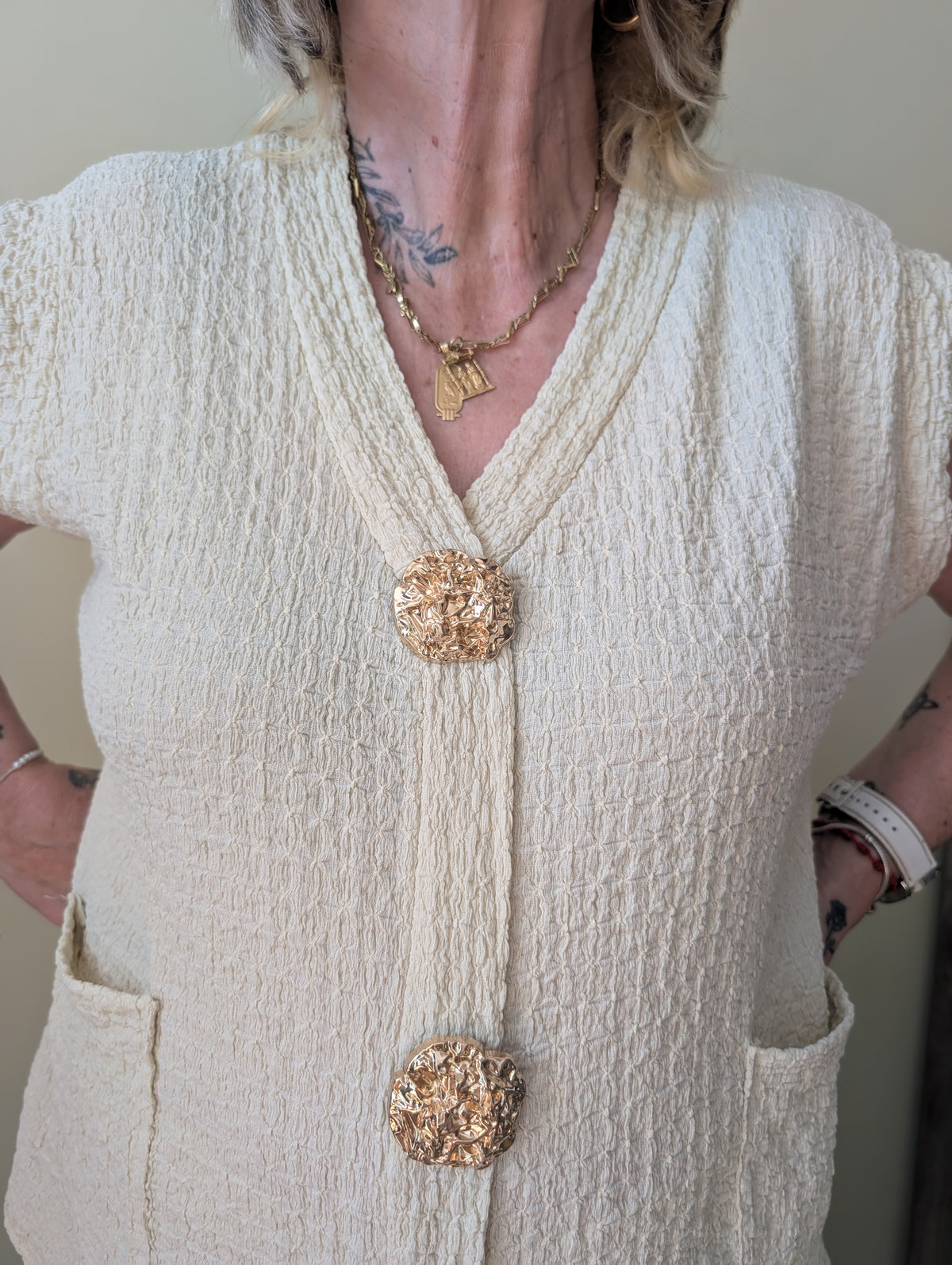 Detalle del conjunto beige con chaleco y pantalón
