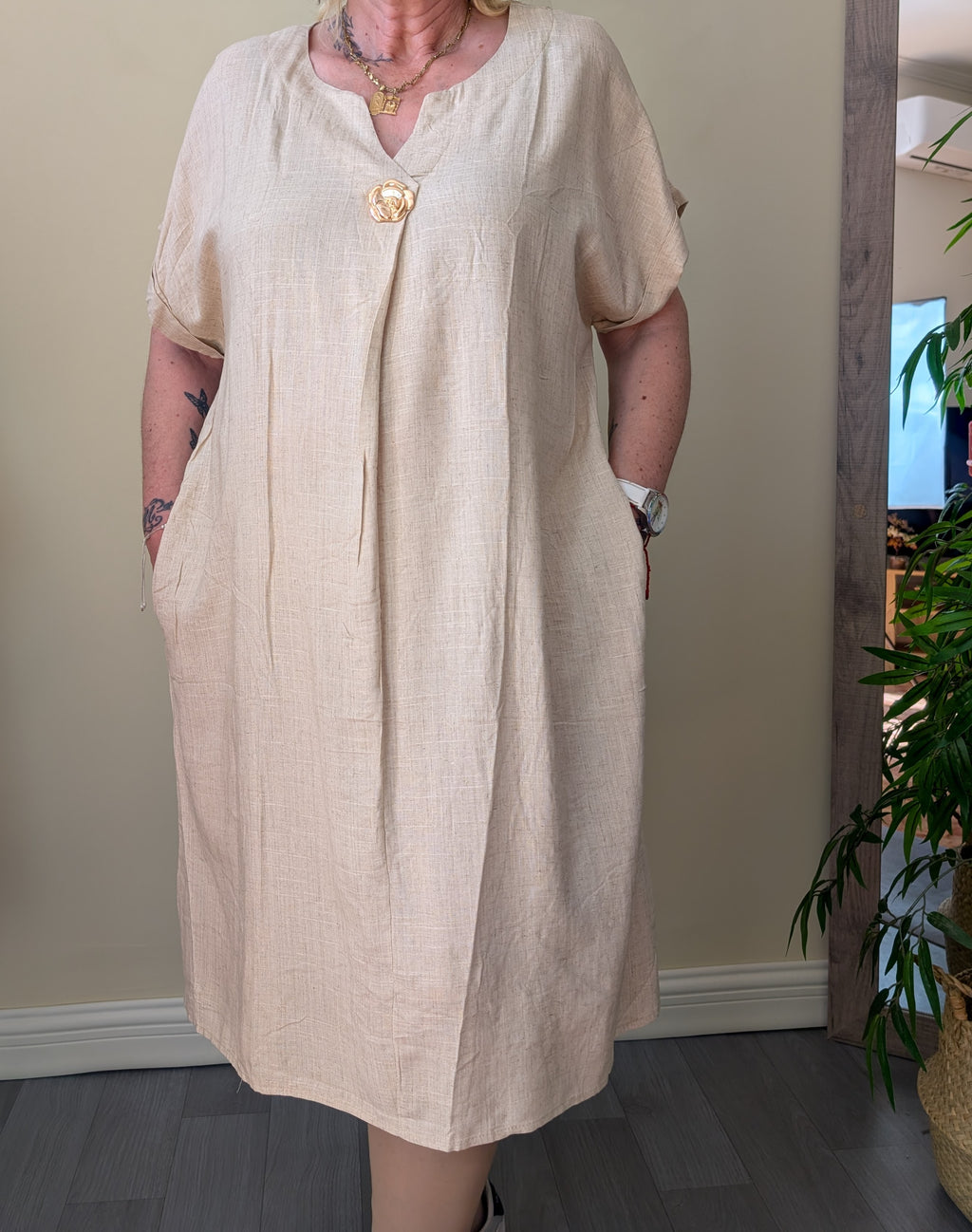 Vestido midi beige de corte amplio con manga corta y bolsillos laterales